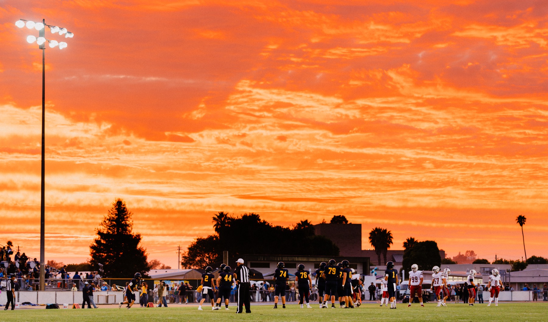A dramatic orange and red sunset sky over the football stadium before Arroyo Grande's home opener
