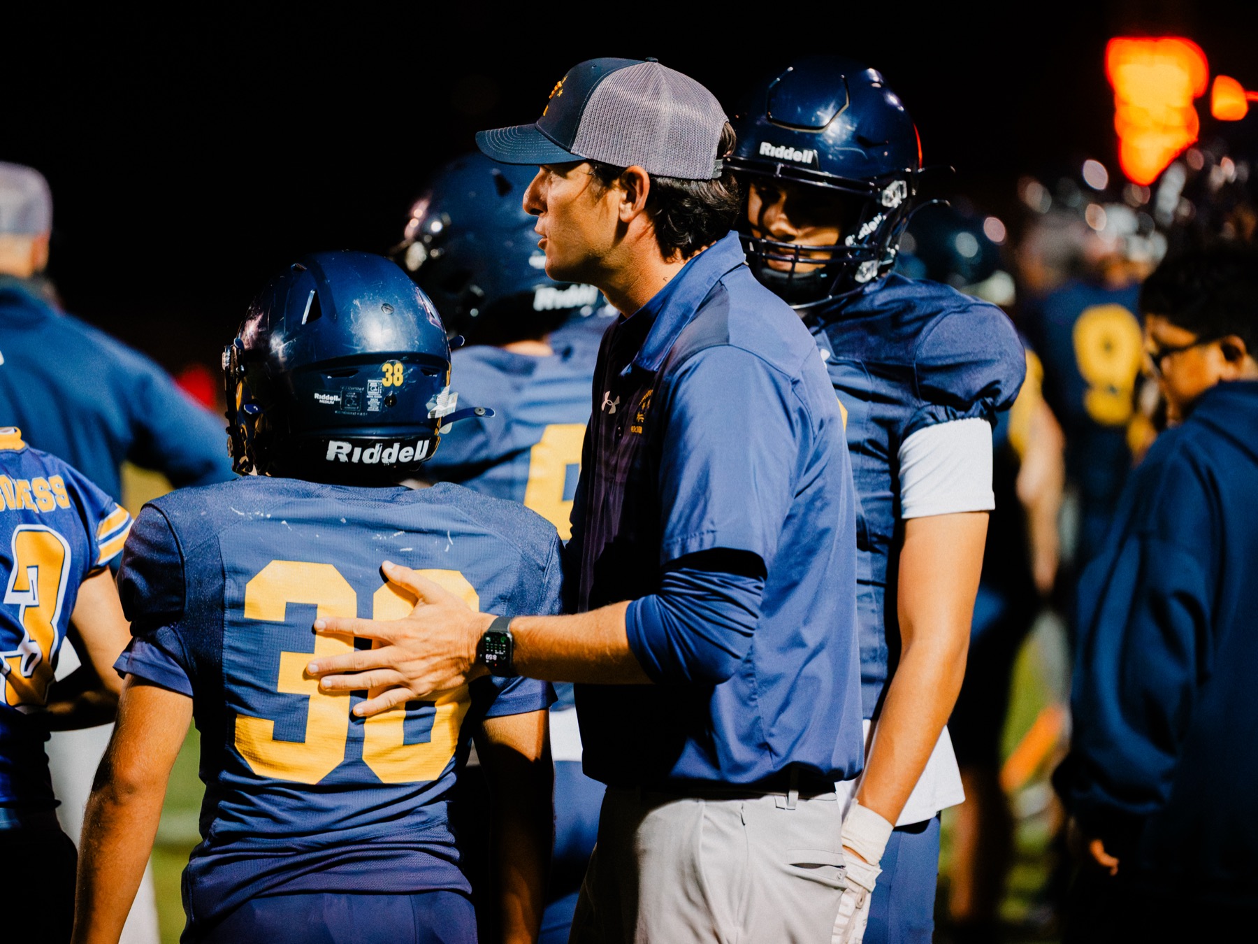 Arroyo Grande players huddle together on the sideline during the game