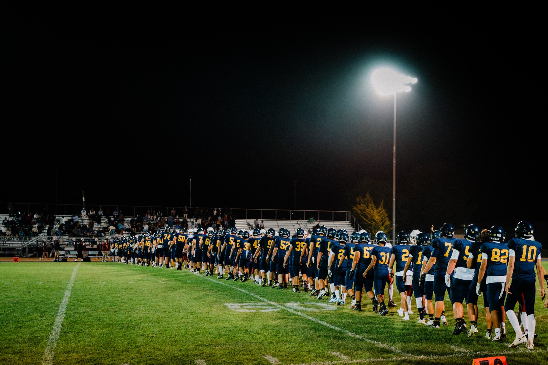 An Arroyo Grande coach talks with a player on the sideline during the game
