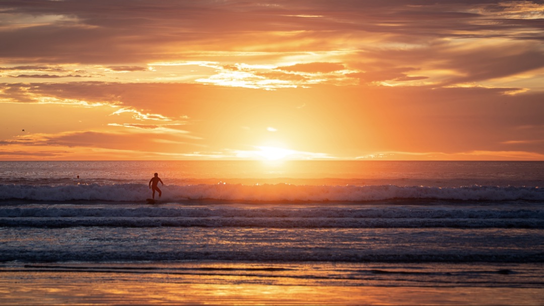 Surfer silhouetted against a blazing Central Coast sunset