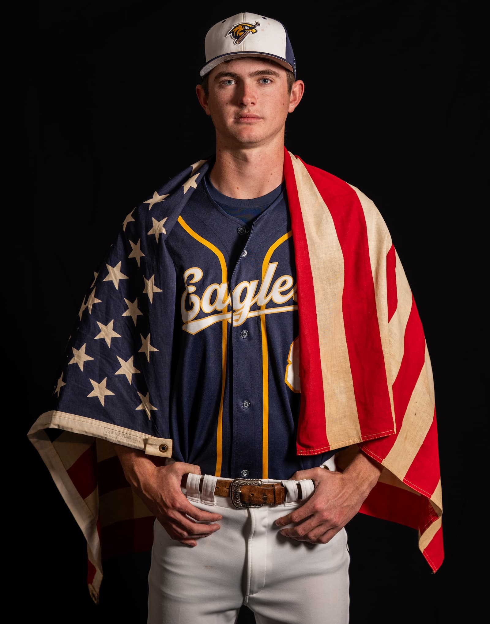 Baseball athlete in Eagles uniform with American flag, dramatic studio lighting
